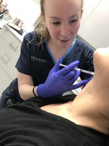 Julie Gessin doing Kybella treatment to remove fat cells from a patient’s chin